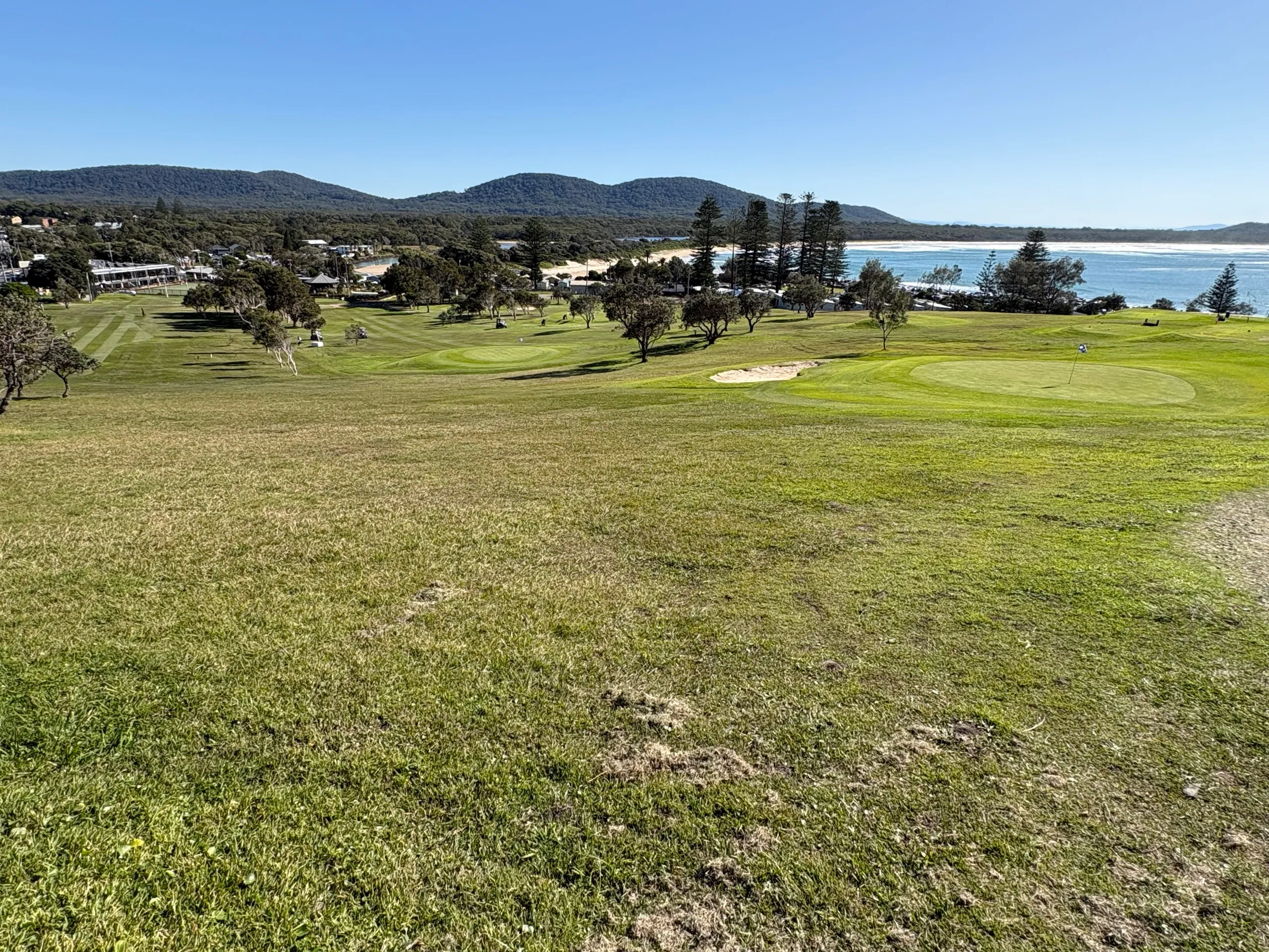 The Crescent Head golf course on the headland with the town and creek beyond