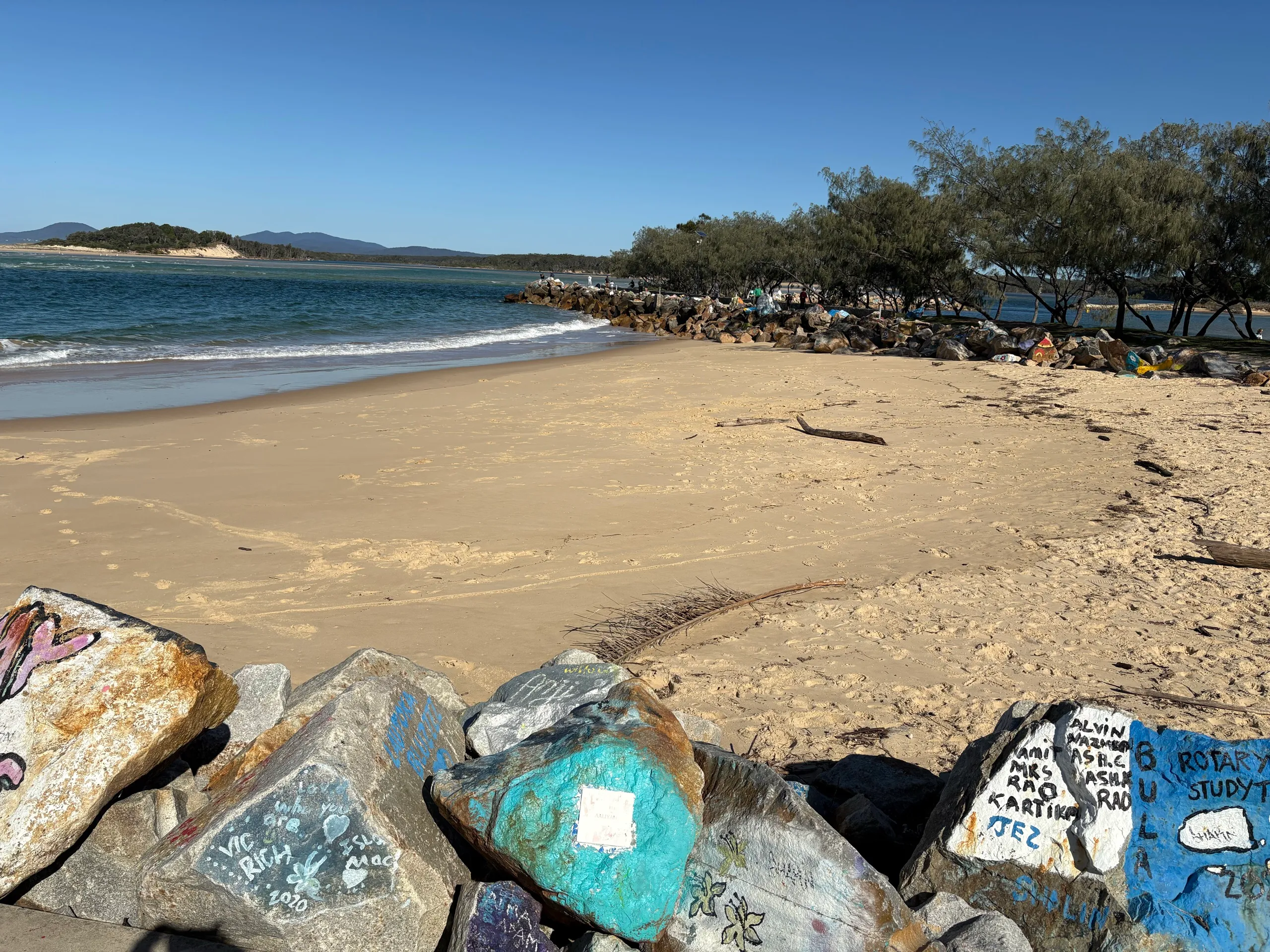 Painted V-Wall rocks beside the calm river beach at Nambucca Heads
