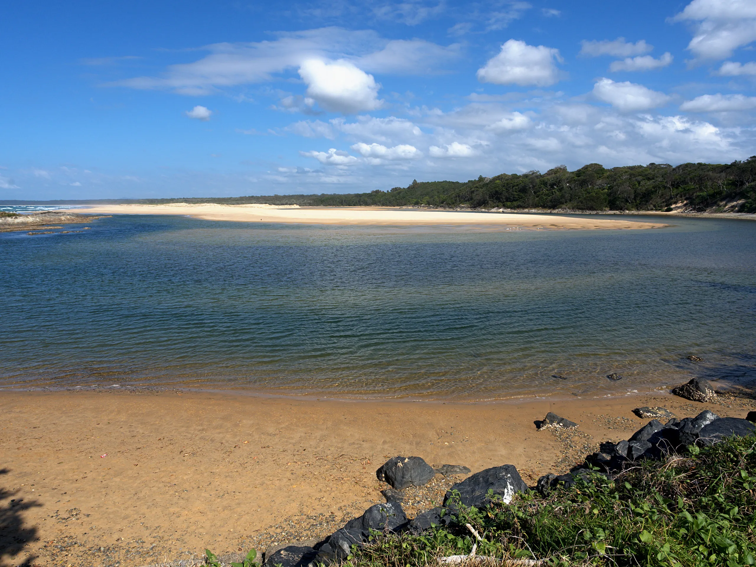 The mouth of Bonville Creek with a wide sandbar and Bonville Beach behind, south of Sawtell