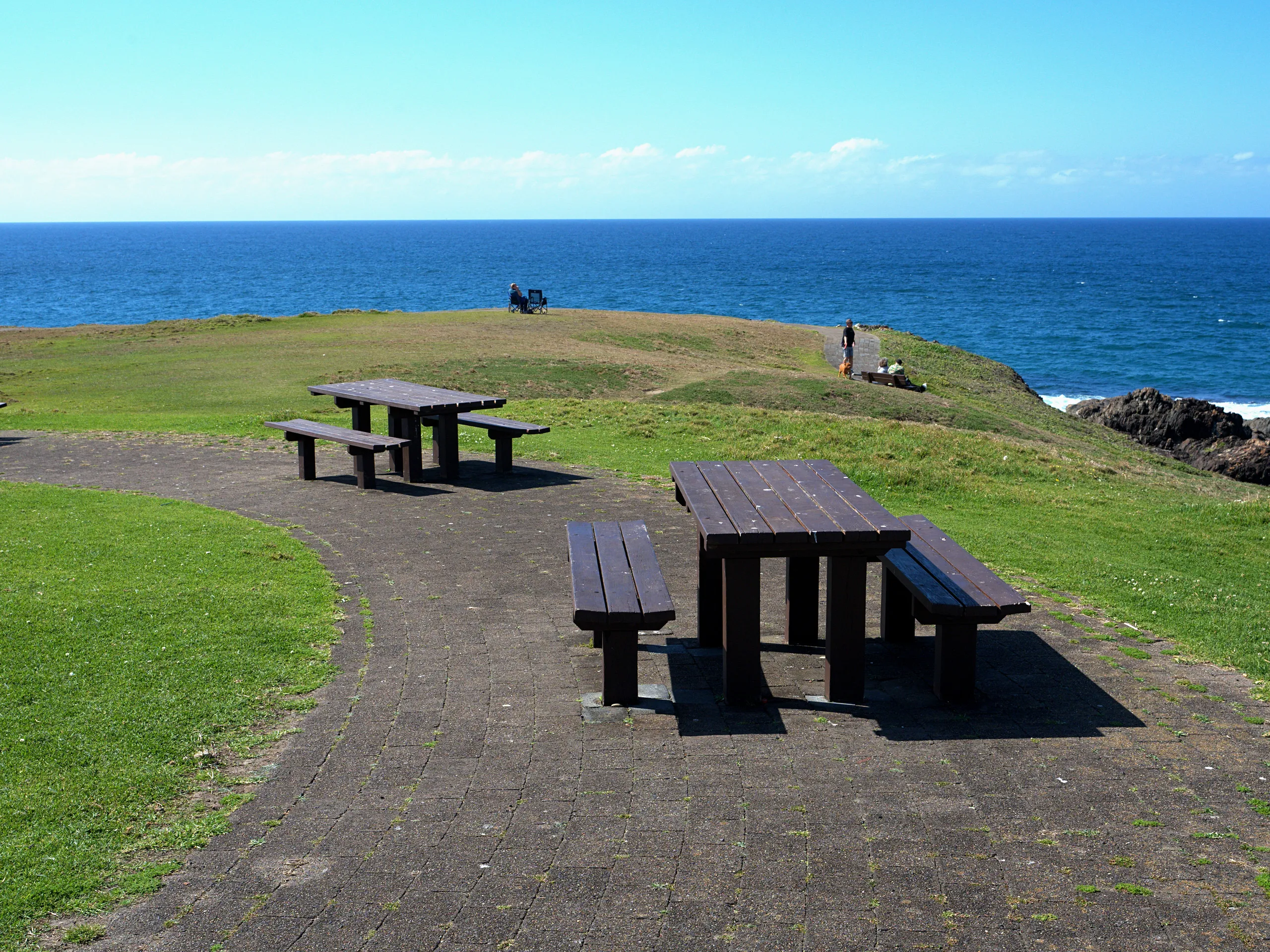 Picnic tables on the grass of the headland reserve above the ocean at Sawtell